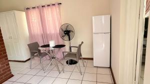 a kitchen with a small table and a refrigerator at Gaxela Space in Pietermaritzburg