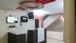 a room with a tv and a ceiling at Hotel Vanice Blue in Indore
