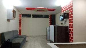 a living room with a couch and a tv at Hotel Vanice Blue in Indore +7 photos