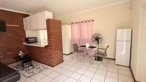 a kitchen with a refrigerator and a table with chairs at Gaxela Space in Pietermaritzburg