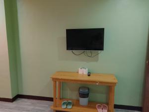 a room with a table with a television on a wall at Coron Sanho Pension in Coron