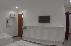 a living room with a tv on a white wall at Coron Sanho Pension in Coron +16 photos