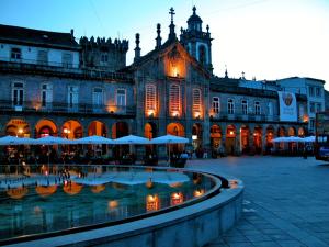 a large building with a fountain in front of it at Bracara Guest House "Arco" in Braga