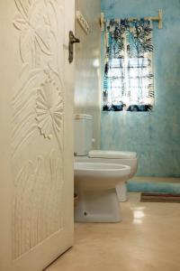 bagno con servizi igienici bianchi e finestra di Ocean zuri villa a Watamu