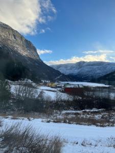 a train in a snowy field with mountains in the background at Bestemorhuset in Øye