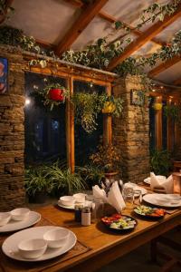 a wooden table with plates of food on it at Buransh Retreat in Jageshwar