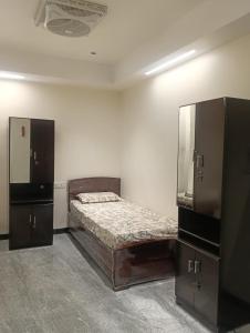 a bedroom with a bed and two dressers in it at Diamond Ridge Living 1RK G-02 in Haidar Sāhibgūda
