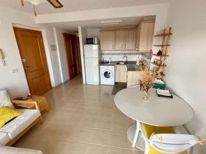 a kitchen with a white table and a white refrigerator at Apartamento en playa de Torrenostra in Torrenostra