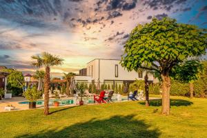 a house with a yard with a pool and palm trees at B&B 1001 nacht in Zonhoven