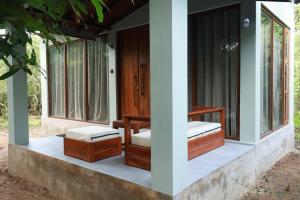 a porch of a house with two beds and windows at Visit Wilpattu in Pahala Maragahawewa