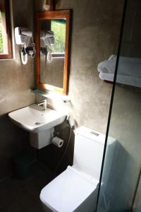 a bathroom with a sink and a toilet and a mirror at Visit Wilpattu in Pahala Maragahawewa +6 photos