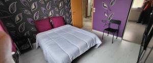 a bedroom with a white bed with pink pillows at Mafadel in Cluny