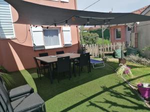 a patio with a table and chairs under an umbrella at Mafadel in Cluny
