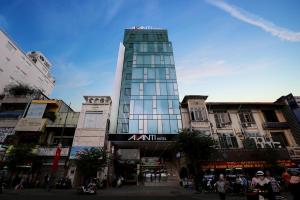 um edifício de vidro alto numa rua da cidade em Avanti Hotel em Ho Chi Minh