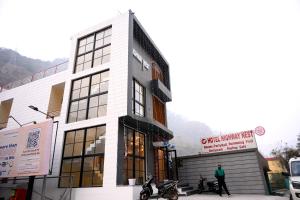 a man is standing in front of a building at Hotel Highway Nest in Chamba