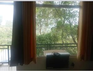 a window with a view of a balcony at Winter Green Resorts, Munnar in Munnar +5 photos