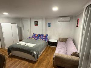 a small bedroom with a bed and a couch at BANI tsikhisdziri in Ts'ikhisdziri