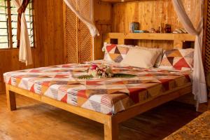 una camera da letto con un letto con una composizione floreale di Ocean zuri villa a Watamu