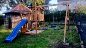 a playground with a blue slide and a play structure at Wilczy Domek nad Witką in Wilka