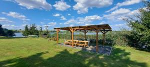 a picnic shelter with two benches in a park at Wilczy Domek nad Witką in Wilka