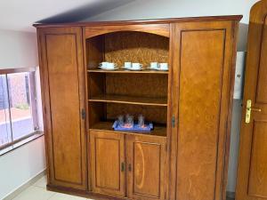 a wooden cabinet with glasses in it in a room at Villa Ipe in Patos de Minas