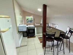 a kitchen with a table and chairs and a refrigerator at Villa Ipe in Patos de Minas