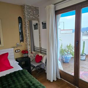 una camera da letto con un letto e una porta scorrevole in vetro di Hostal La Garita a Peñíscola