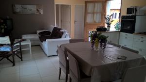 a living room with a table and a couch at Gîte A l'orée des bois in Saint-Robert