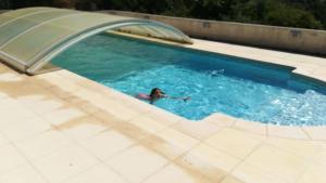 a person swimming in a swimming pool at Gîte A l'orée des bois in Saint-Robert