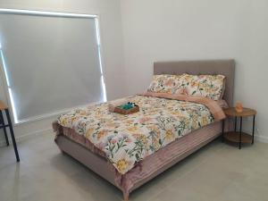 a small bed in a bedroom with a table at Quiet Spacious Room in a Shared Family Home in Yarrabilba in Plunkett Station +2 photos