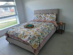 a bedroom with a bed with a blanket and a window at Quiet Spacious Room in a Shared Family Home in Yarrabilba in Plunkett Station