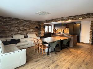 a kitchen and living room with a table and a couch at Apartmán Horal in Jilemnice +16 photos