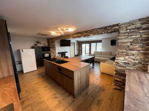 a kitchen and living room with a stone wall at Apartmán Horal in Jilemnice