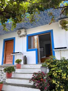 een blauw en wit huis met trappen en bloemen bij a perfect room in Borsh