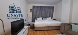 een slaapkamer met een bed, een tv en een bank bij Linaste at Colosseum in Johannesburg