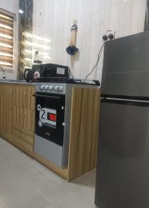 a kitchen with a stove and a refrigerator at Travel Lodge Apartment in Sagisa