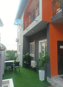 a house with a yard with green grass at Travel Lodge Apartment in Sagisa