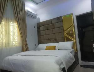 a bedroom with a large bed and a television at Travel Lodge Apartment in Sagisa