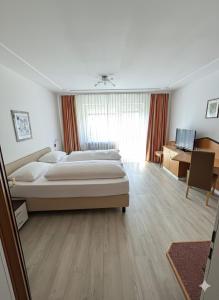 duża sypialnia z dużym łóżkiem i biurkiem w obiekcie Gästehaus am Kurpark w mieście Villingen-Schwenningen