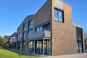 a brick building with a balcony on a street at Ankerix & Deichfix in Büsum