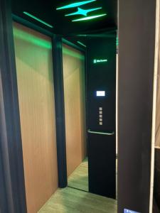 an elevator in a hallway with a green light at Hotel Golden Night Star in Shah Alam