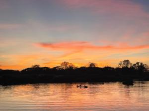 Due persone in barca su un lago al tramonto di Tena Guest House a Don Det