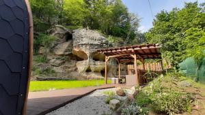 a pavilion in a garden with a rock wall at Wellness Kokořín in Kokořín