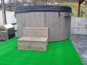 een houten container met een bankje op een groen tapijt bij Casa Alex in Curtea de Argeş +26 foto's