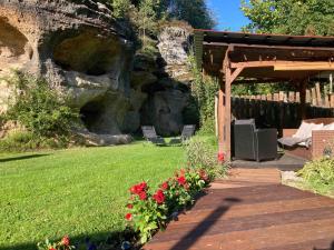 a garden with a wooden walkway and some flowers at Wellness Kokořín in Kokořín