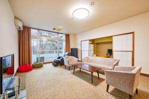 a living room with a couch and chairs and a tv at Shiki Resorts Kusatsu Saisonnier in Kusatsu +7 photos
