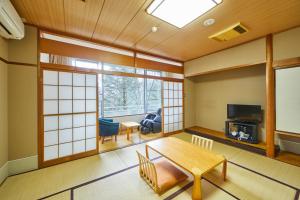 a living room with a table and a window at Shiki Resorts Kusatsu Saisonnier in Kusatsu