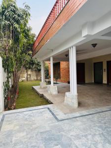 a courtyard with a building with columns and trees at Hotel living spot in Lahore +18 photos