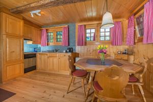 ツェルマットにあるChalet Tuk-Tukのキッチン(木製キャビネット、木製テーブル、椅子付)