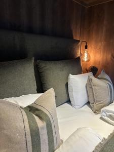een slaapkamer met een bed met kussens en een lamp bij Fjelleventyret gårdsovernatting in Skjåk